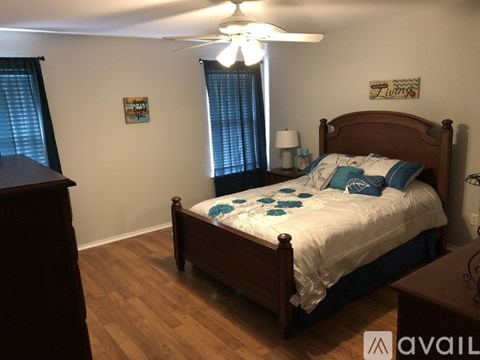 A bedroom with a bed, nightstand, and a ceiling fan.