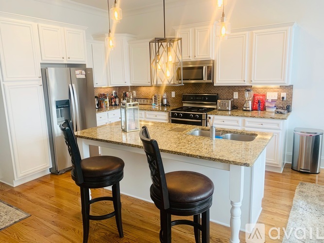 A kitchen with a granite countertop and two bar stools.