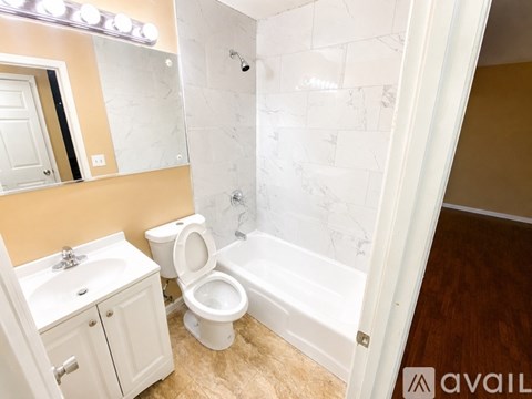 A bathroom with a toilet, sink, and bathtub.