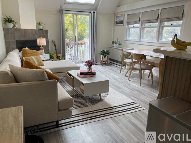 A living room with a couch, coffee table, and a dining table.