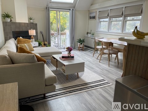 A living room with a couch, coffee table, and a dining table.