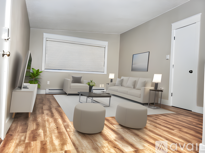 A modern living room with a white sofa set, a wooden floor, and a large window with blinds.