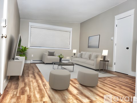 A modern living room with a white sofa set, a wooden floor, and a large window with blinds.