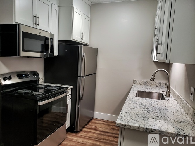 A kitchen with black appliances and a granite countertop.