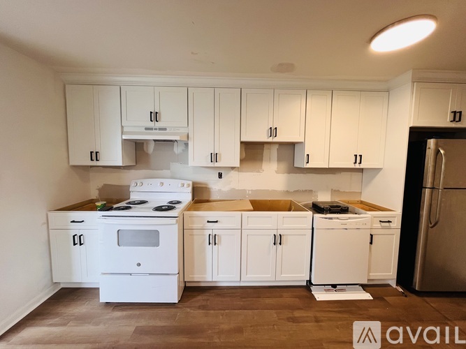 A kitchen with white cabinets and appliances is available for rent.