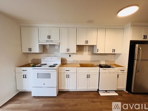 A kitchen with white cabinets and appliances is available for rent.