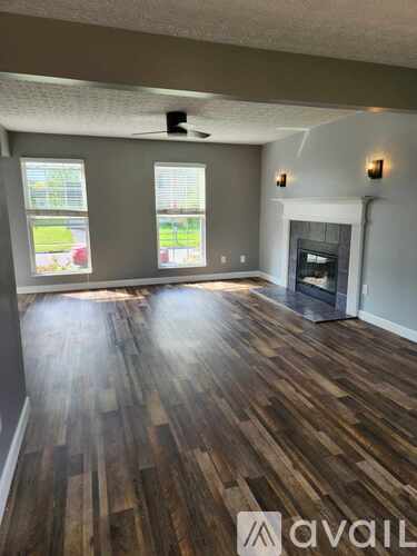 A room with wooden flooring and a ceiling fan.