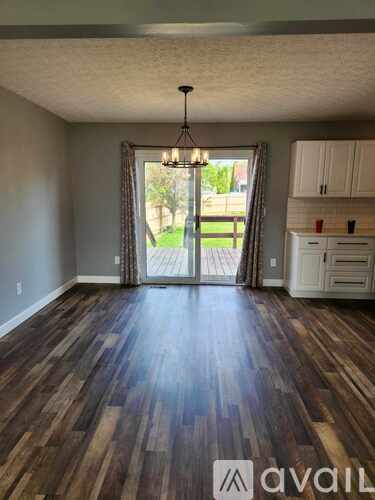 A room with wooden flooring and a chandelier.