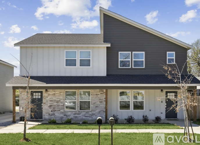 A modern house with a grey roof and white walls.