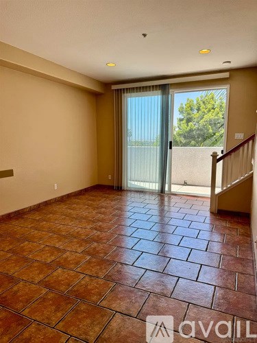 A room with tiled flooring and a sliding glass door leading outside.
