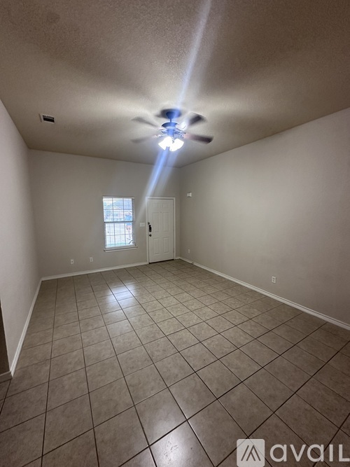 A room with a ceiling fan and tiled floor.