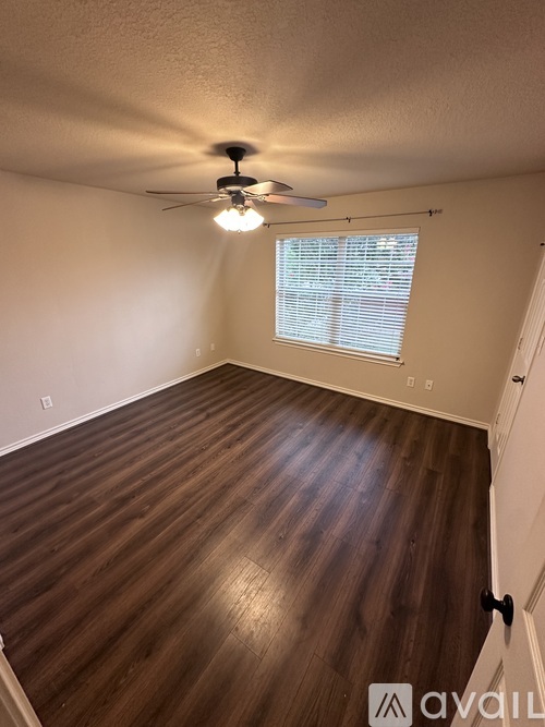 A room with wooden flooring and a ceiling fan.