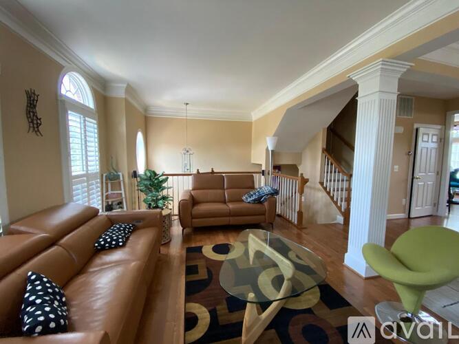 A living room with a brown leather couch and a green chair.