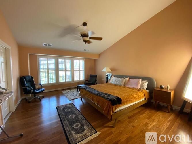 A bedroom with a bed, chair, and window.