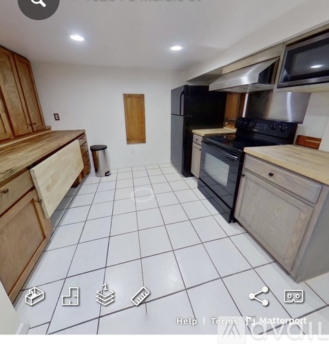 A kitchen with black appliances and wooden cabinets.