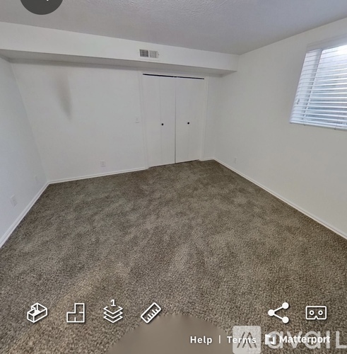 A room with a carpeted floor and a sliding door.