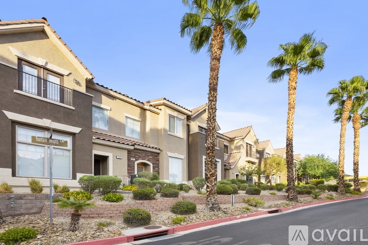 A row of houses with palm trees in front.