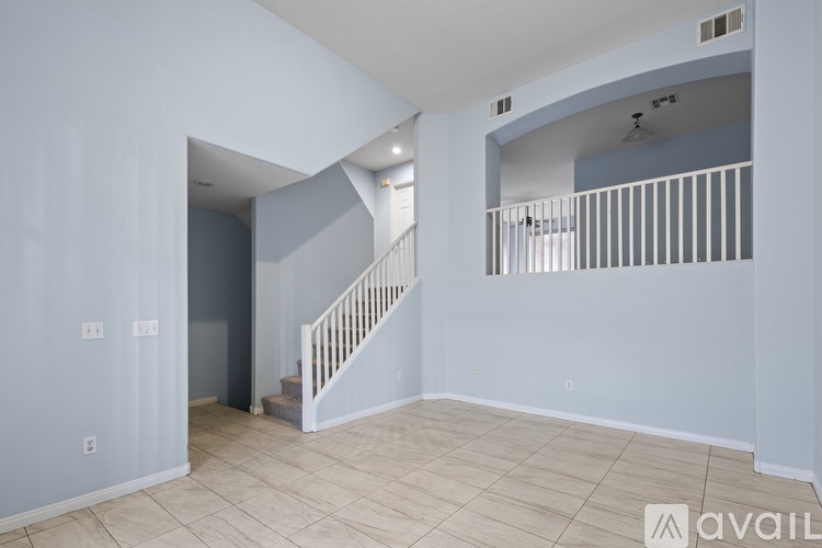 A spacious room with a staircase and a balcony.