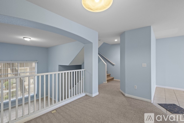 A living space with a carpeted floor and a staircase leading to another room.
