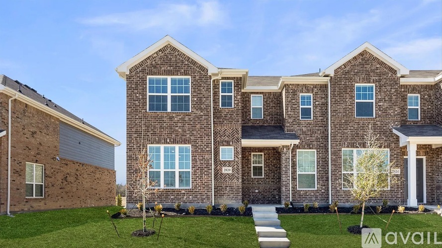 A large brick house with a front yard and a sign that says "available".