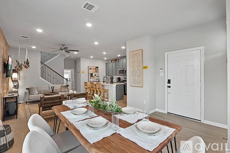 A dining room with a wooden table set for two.