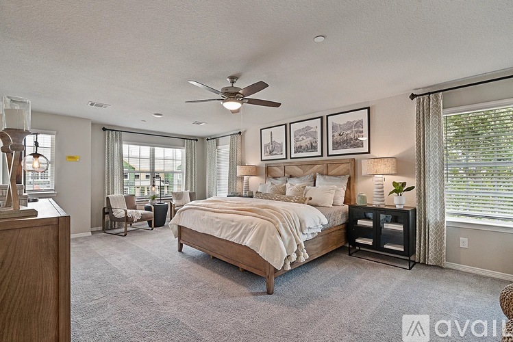 A bedroom with a large bed and a ceiling fan.