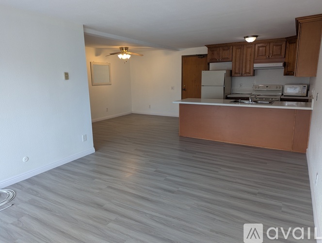 A kitchen with a white wall and a brown counter.