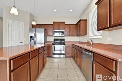 A kitchen with brown cabinets and stainless steel appliances.