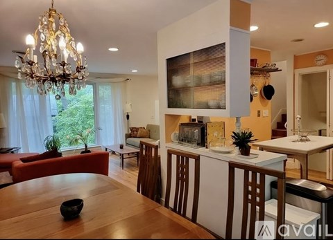 A modern kitchen with a wooden table and a chandelier.