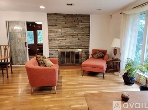 A living room with a stone wall and a fireplace.