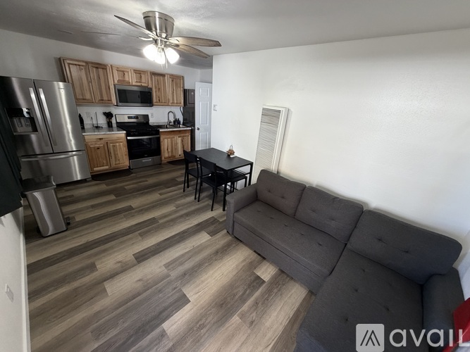 A kitchen with a refrigerator, microwave, oven, and sink.