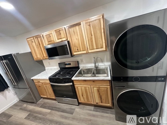 A kitchen with wooden cabinets and a black dishwasher.