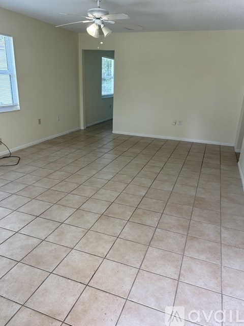 A room with a tile floor and a ceiling fan.