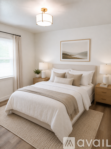 A bedroom with a large bed and a framed picture on the wall.