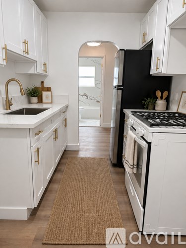 A kitchen with white cabinets and a black refrigerator.
