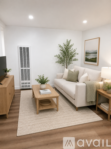 A living room with a white couch, a wooden coffee table, and a plant.
