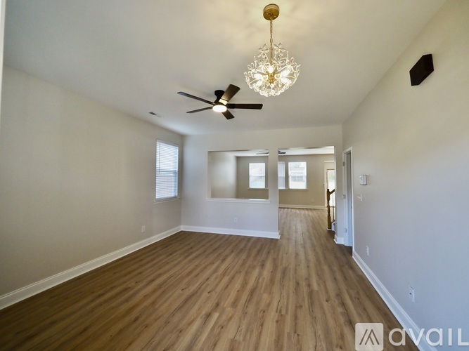 A spacious room with a chandelier and a ceiling fan.