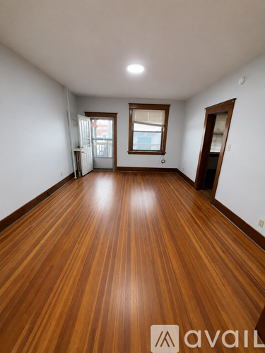 A room with wooden flooring and a window.
