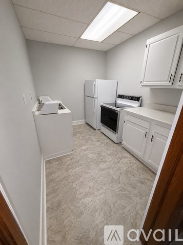 A kitchen with white appliances and cabinets.