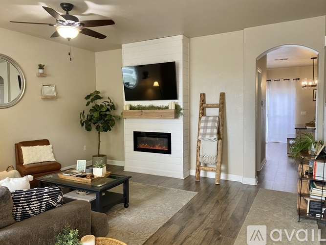 A living room with a fireplace and a television on the wall.