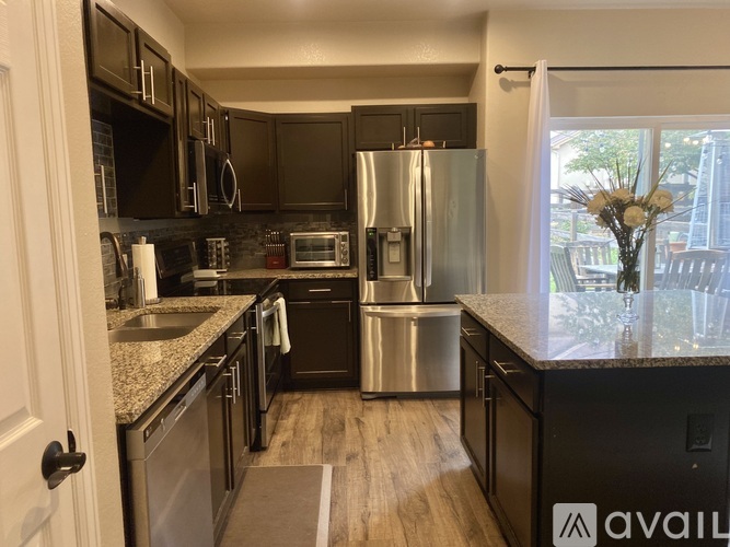 A kitchen with dark brown cabinets and stainless steel appliances.