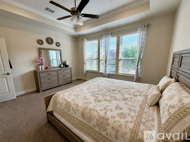 A bedroom with a large bed and a ceiling fan.