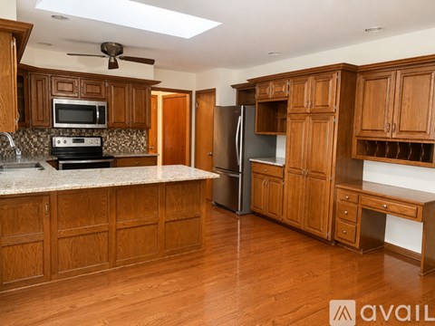 A kitchen with wooden cabinets and a marble countertop.
