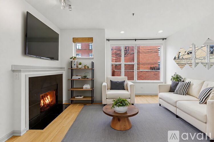 A living room with a fireplace and a television mounted on the wall.
