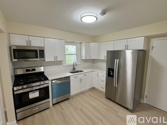 A kitchen with a stove, oven, sink, and refrigerator.