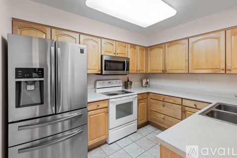 A kitchen with wooden cabinets and stainless steel appliances.