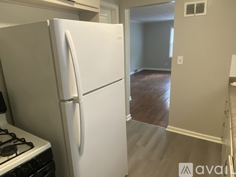 A white refrigerator is in a kitchen next to a stove.