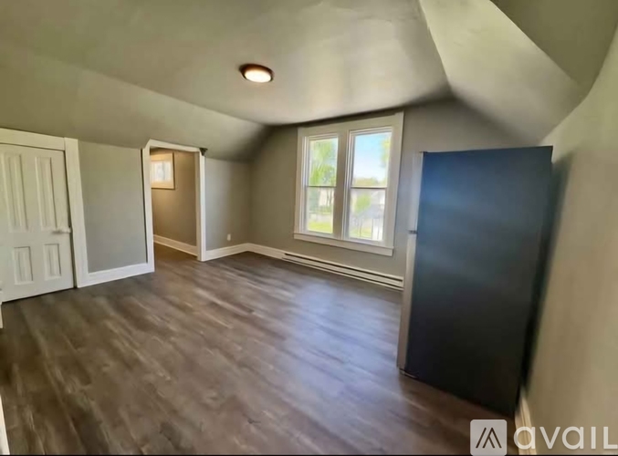 A room with a window and a door is available for rent.
