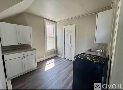 A kitchen with white cabinets and a black stove top oven.