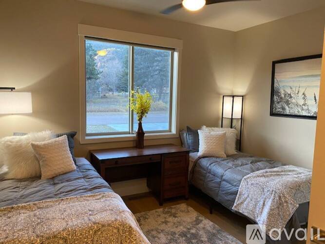 A bedroom with two beds and a window.